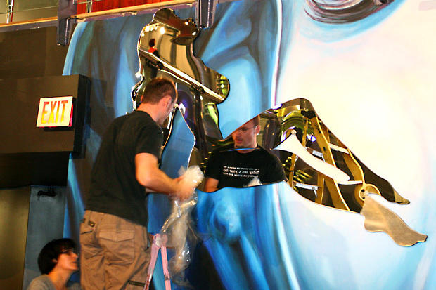 Installers remove protective coating from decorative laser cut mirror mud flap girl silhouettes in night club - Circa Toronto
