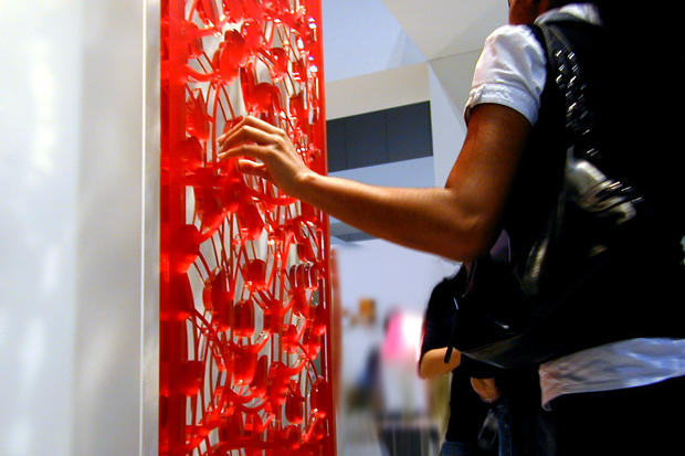 Designer touching decorative laser cut panel at IIDEX Interior design show 2007 in Toronto - Art Signs Company.