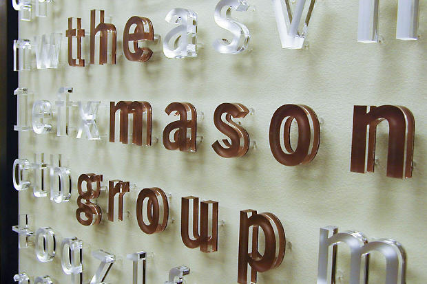 Raised decorative frosted acrylic signage letters as lobby sign behind desk in reception area - Art Signs Company