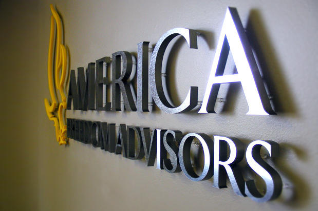Corporate logo sign with brushed metal finish to match stainless steel look, waiting area wall installation