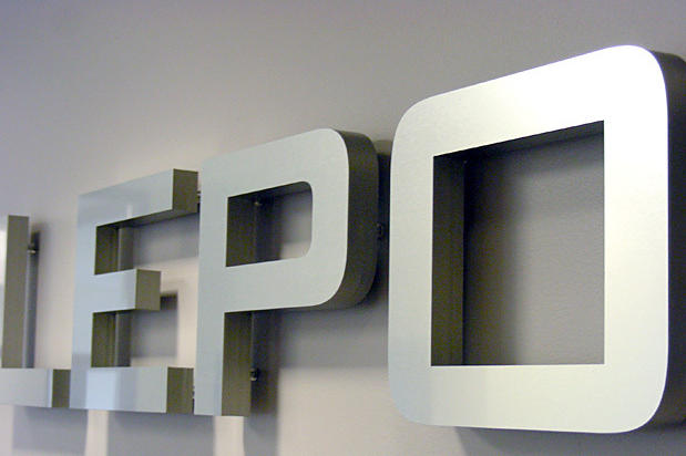 Close-up of 3D dimensional metal letters mounted on drywall for a modern office interior sign