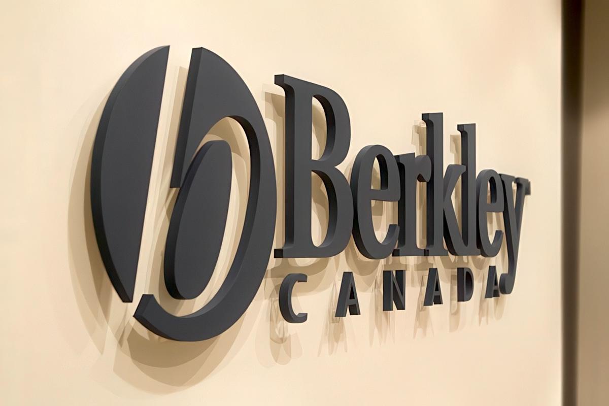 3D custom acrylic office wall sign with custom-matched dark grey paint, precision-cut letters and logo mounted with spacers for a modern corporate interior.