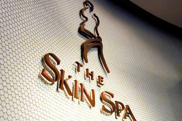 3D office lobby sign made with laser cut copper metal letters and symbols raised off the wall individually on spacers for floating effect.