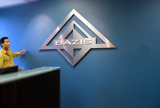 Corporate logo sign with brushed metal finish to match stainless steel look, waiting area wall installation