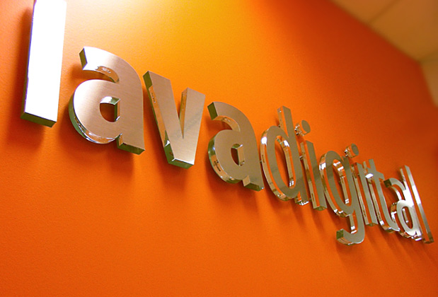 Corporate logo sign with brushed metal finish to match stainless steel look, waiting area wall installation
